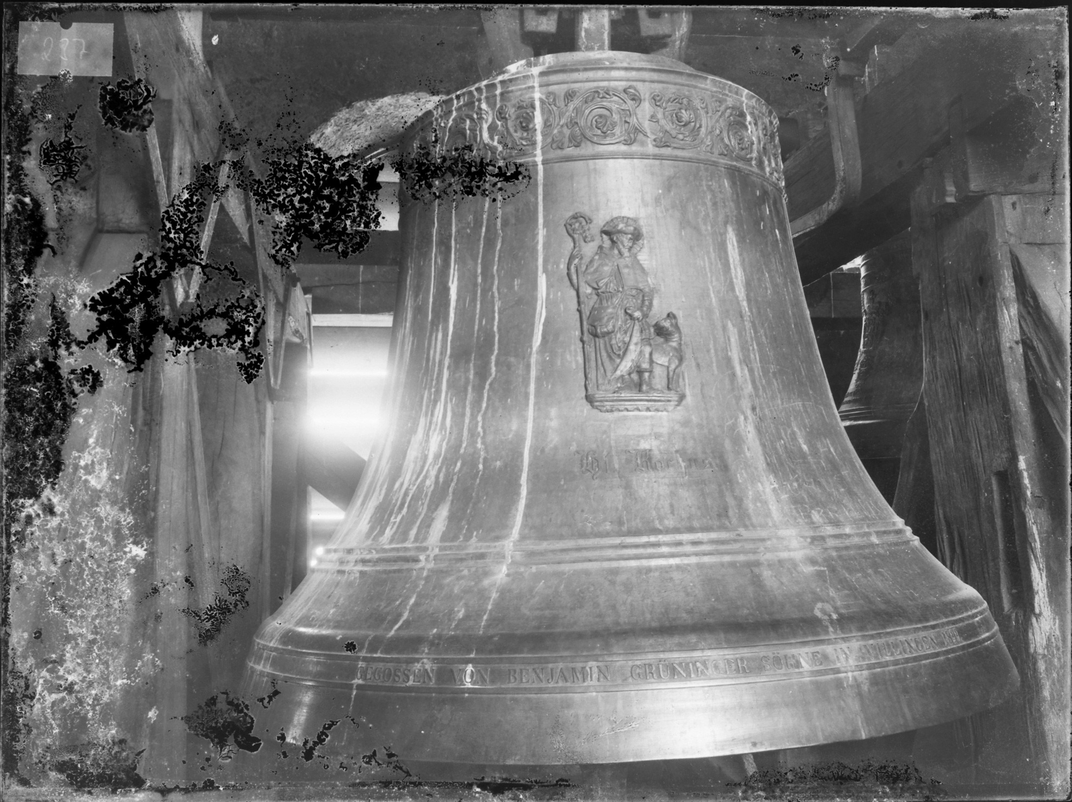 Die Pfarrkirche St. Oswald in Buchen verfügte zu Beginn des 20. Jahrhunderts, als die Aufnahme entstand, über ein fünfstimmiges Geläut. Drei Glocken waren 1899 von der Villinger Glockengießerei Grüninger neu gegossen worden, darunter die abgebildete Rochusglocke. Während die Grüninger-Glocken den Ersten Weltkrieg unbeschadet überstanden, wurden die beiden älteren, aus dem 18. Jahrhundert stammenden Glocken eingeschmolzen. Zwei der Grüninger-Glocken, darunter die Rochusglocke, wurden schließlich 1942 eingeschmolzen, so dass nur noch die dem Kirchenpatron St. Oswald geweihte Glocke von 1899 übrig war. 1949 erhielt das Geläut drei neue Glocken, 1976 kam eine neue Rochusglocke hinzu, so dass das Geläut seither wieder fünfstimmig ist.