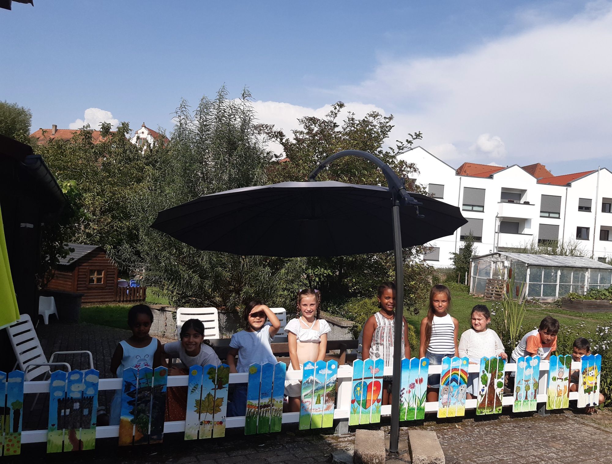 Kinder mit dem Zaun-Kunstwerk
