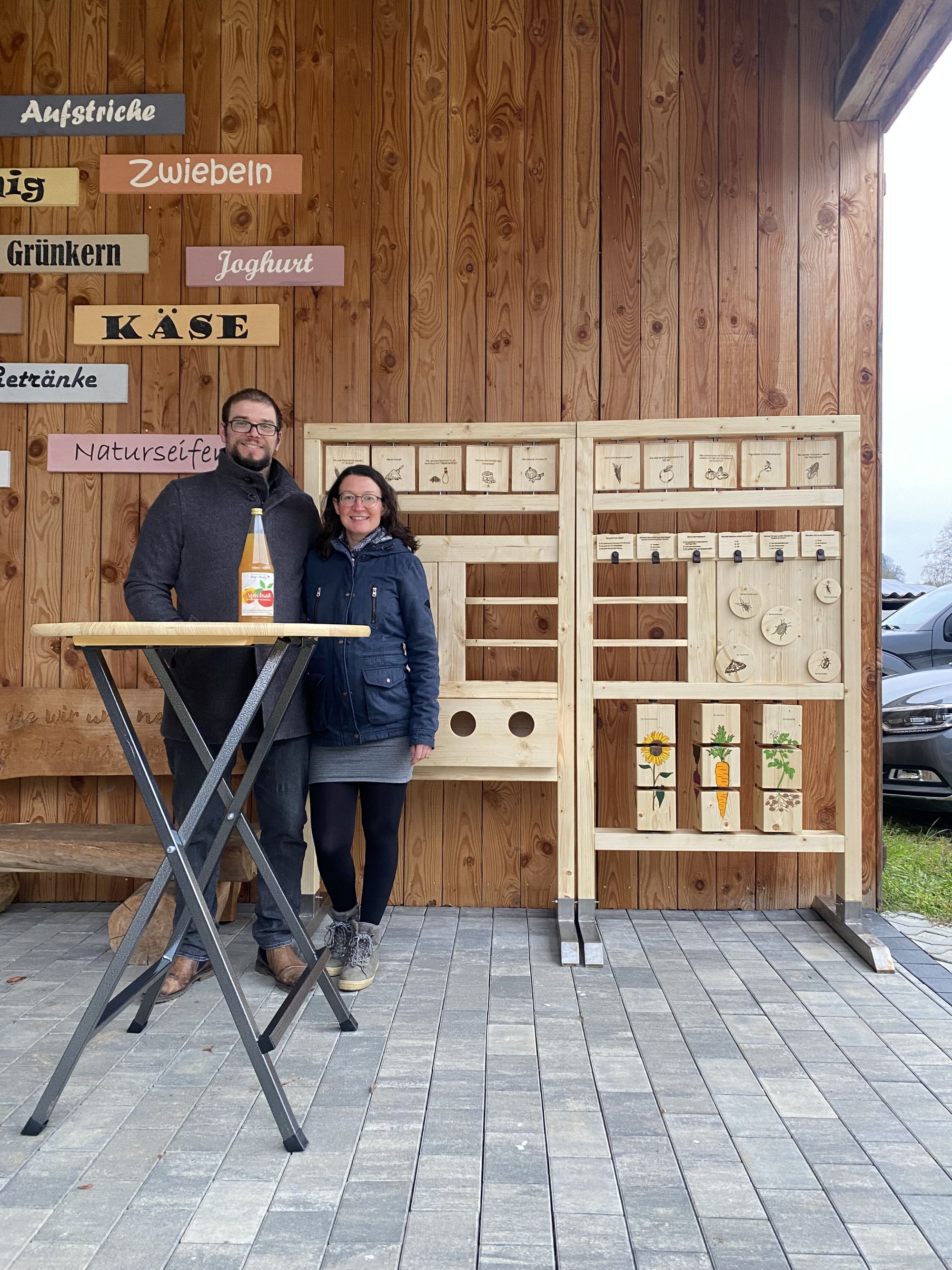 Der Hofladen Heilig in Hardheim-Gerichtstetten - eine erfolgreiche Projektreihe aus den vergangenen Jahren. Das Bild zeigt Jenny und Matthias Heilig vor Ihrem Hofladen mit der inklusiven Holzquiztafel die bei Veranstaltungen zum Einsatz kommt. Der Hofladen Heilig in Hardheim-Gerichtstetten - eine erfolgreiche Projektreihe aus den vergangenen Jahren. Das Bild zeigt Jenny und Matthias Heilig vor Ihrem Hofladen mit der inklusiven Holzquiztafel die bei Veranstaltungen zum Einsatz kommt.